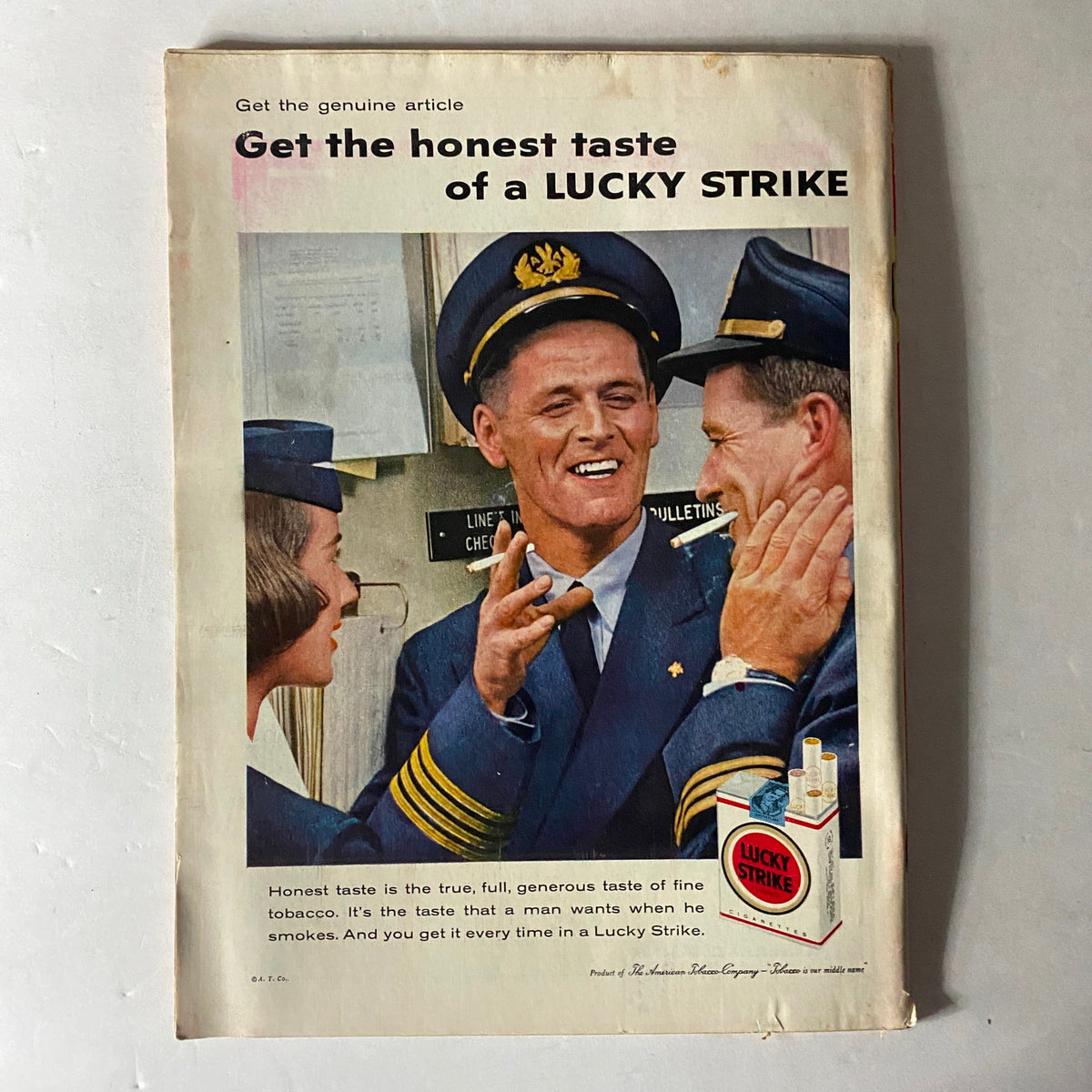 Vintage advertisement featuring a friendly interaction between three airline crew members, promoting the honest taste of a Lucky Strike cigarette, with the tagline: 'Get the honest taste of a LUCKY STRIKE'. This image aligns with the Time Magazine October 20, 1958 Vol 72 No. 16 Nonagenarian A. A. Stagg Cover.