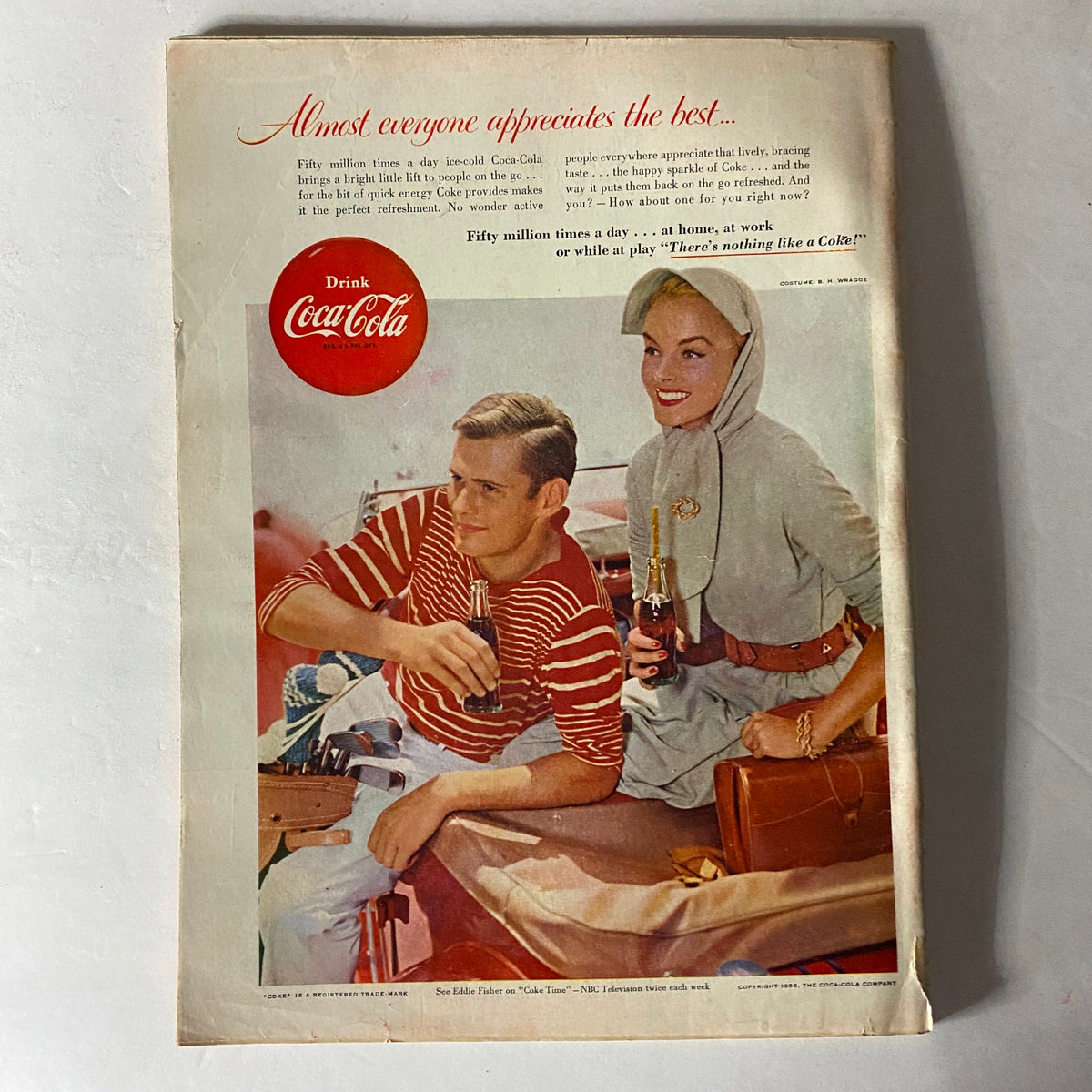 Vintage advertisement for Coca-Cola from 1955, featuring a young couple enjoying drinks by the water, promoting the refreshing taste of Coke.