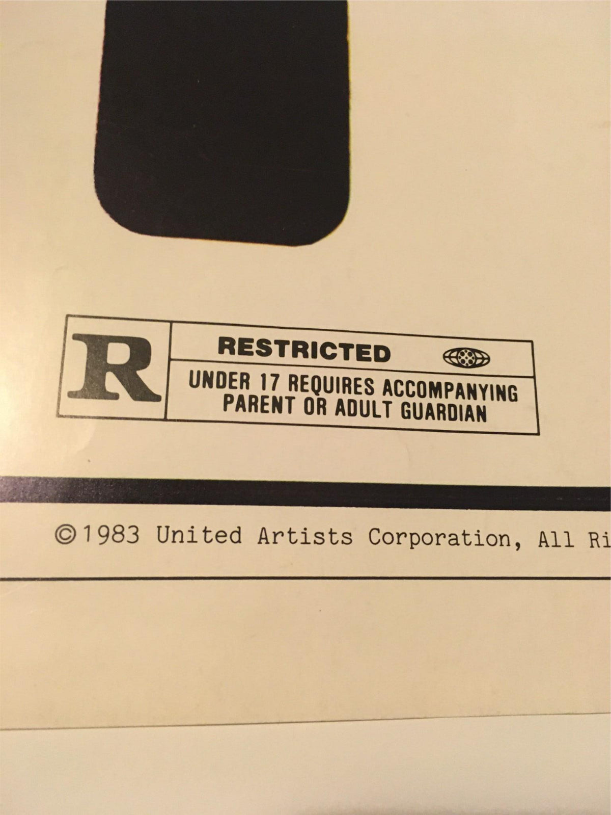 Close-up of the 1983 Exposed movie poster showing the R rating label. It reads 'UNDER 17 REQUIRES ACCOMPANYING PARENT OR ADULT GUARDIAN', highlighting its restricted content.