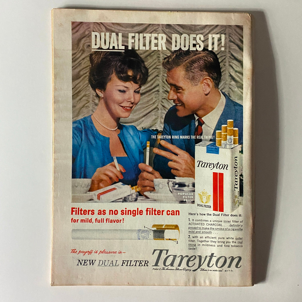 Advertisement for Tareyton cigarettes featured in a vintage magazine, emphasizing dual filter technology with a couple enjoying a moment together.