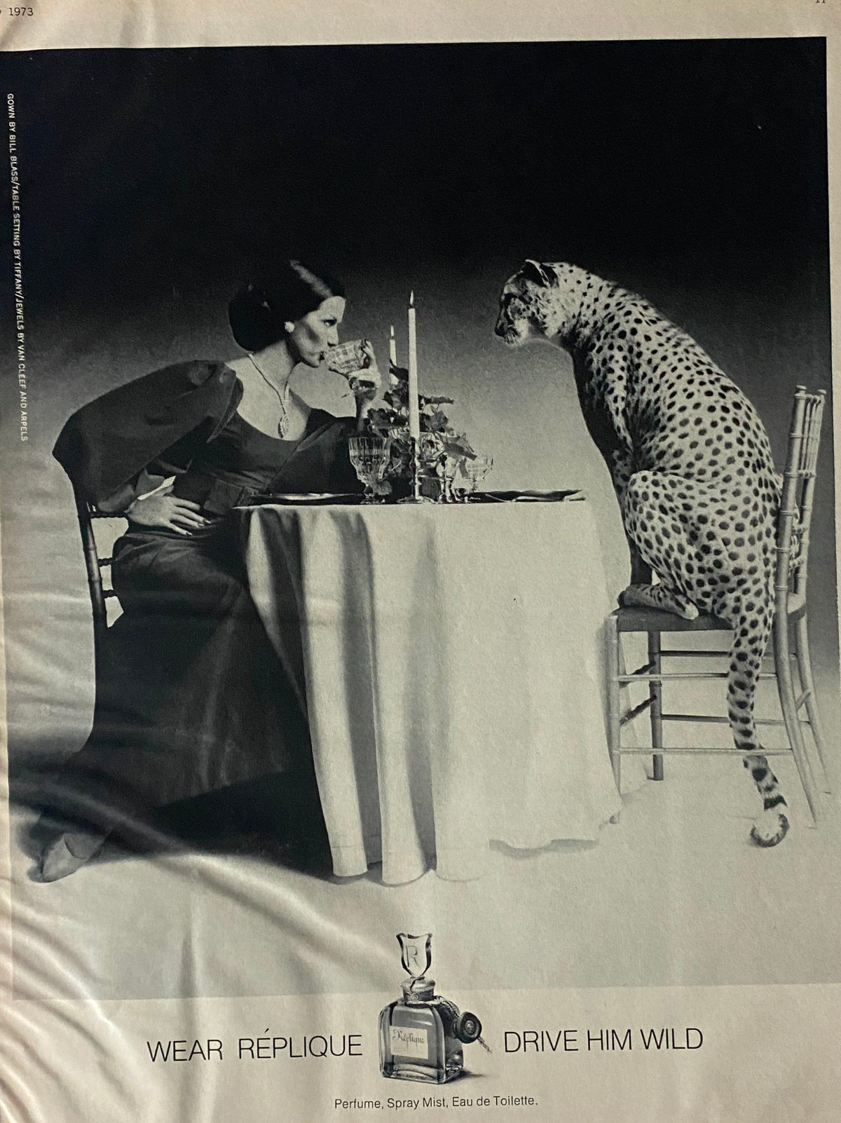 Advertisement from Harper's Bazaar Magazine July 1973 featuring a woman dining at a table with a leopard, emphasizing fashion and allure.