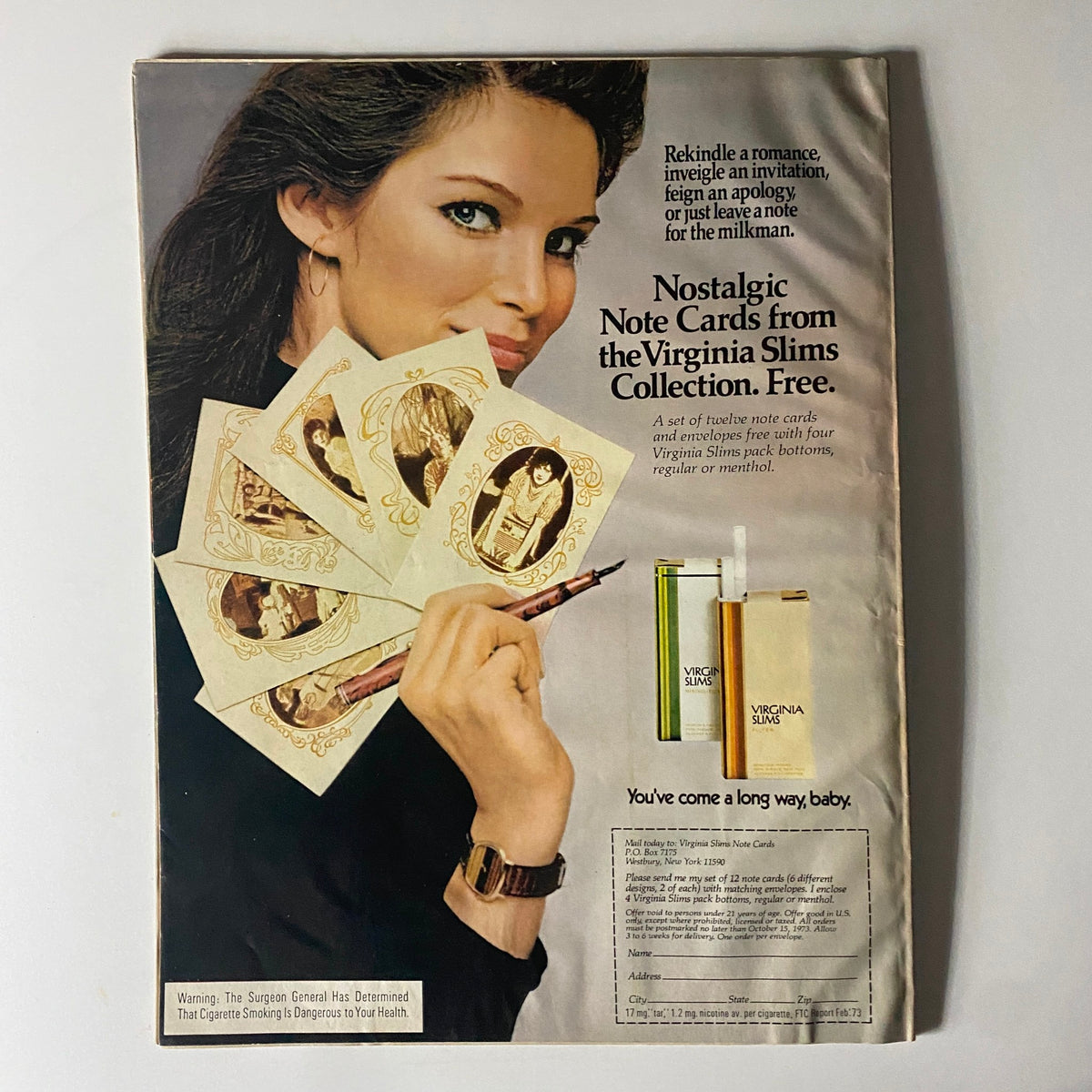 Back cover of Harper's Bazaar Magazine July 1973 showcasing a woman promoting Virginia Slims cigarette note cards, highlighting nostalgia in advertising.