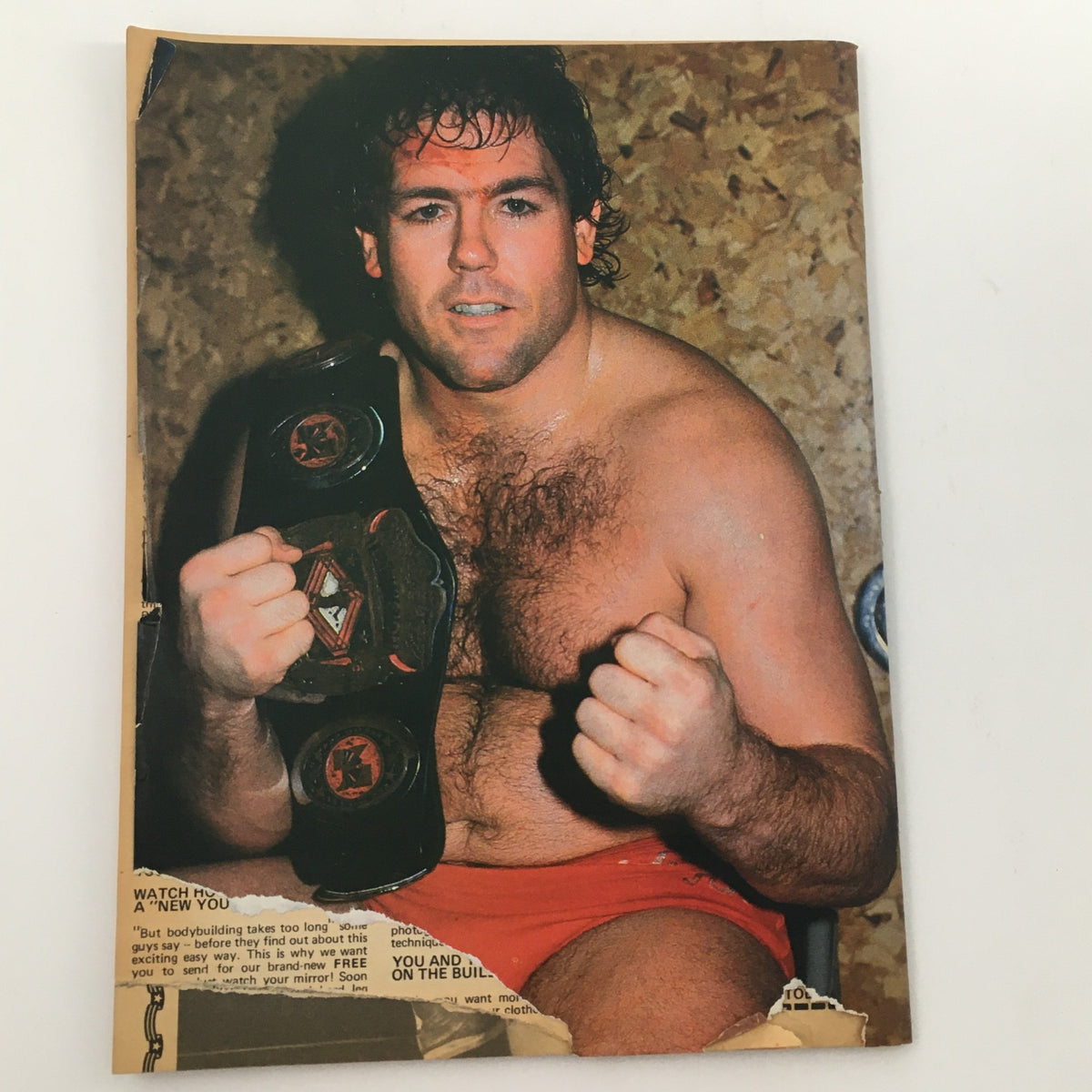 A wrestler holding a championship belt from Wrestling Scene Magazine July 1985 Issue #23. The wrestler appears confident, capturing the spirit of professional wrestling.