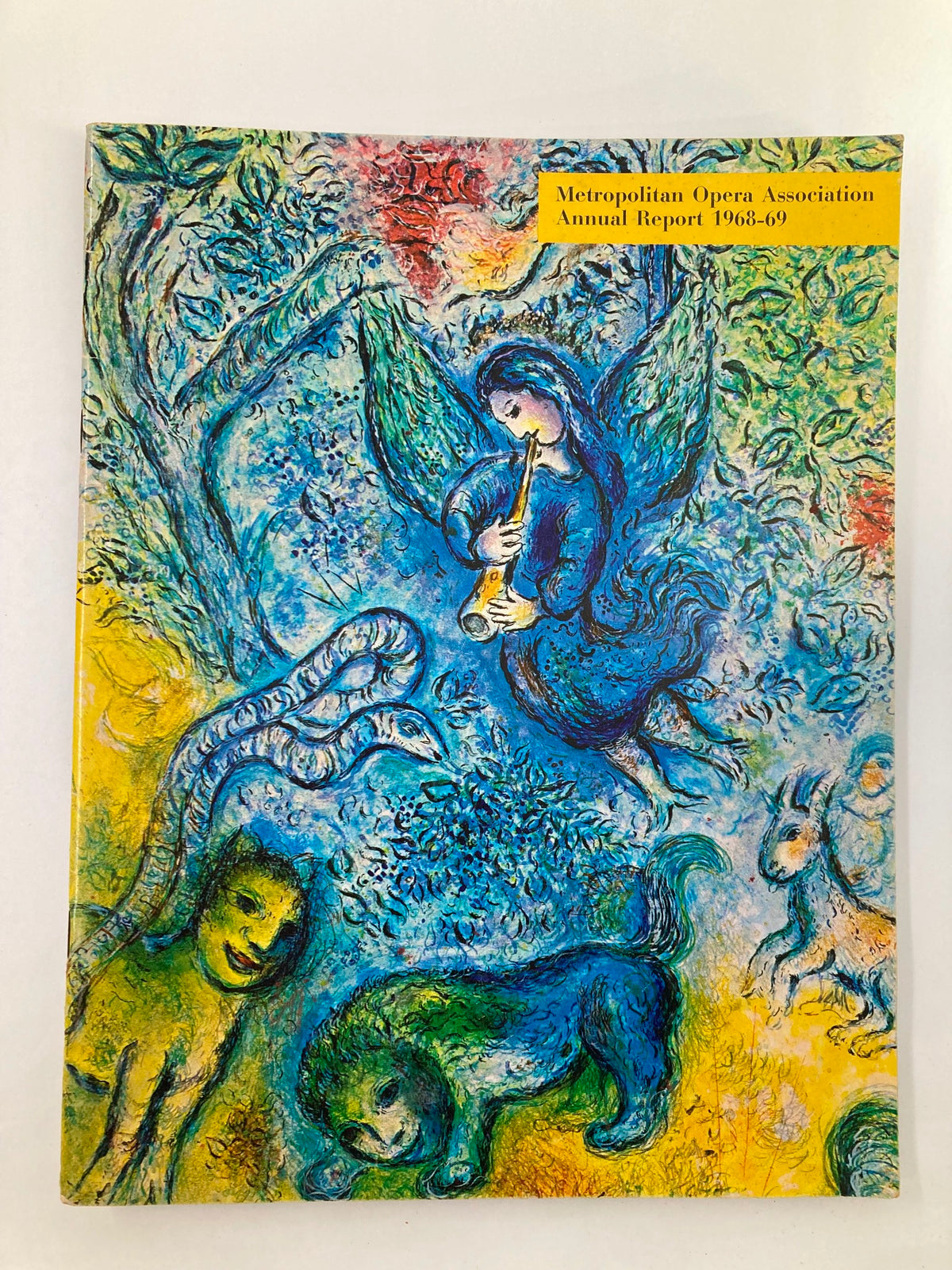 Cover of the 1968 Program Souvenir Metropolitan Opera Association Annual Report featuring vibrant artwork with an angel playing a flute amidst animals and nature.