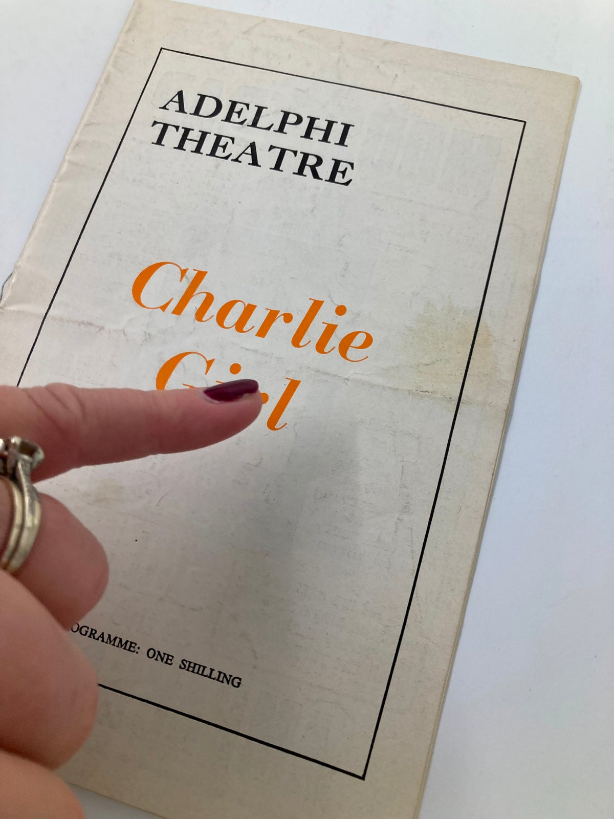 Cover of the 1965 Program from Adelphi Theatre featuring 'Charlie Girl' with a finger pointing at the title. Original theatre memorabilia with vintage charm.