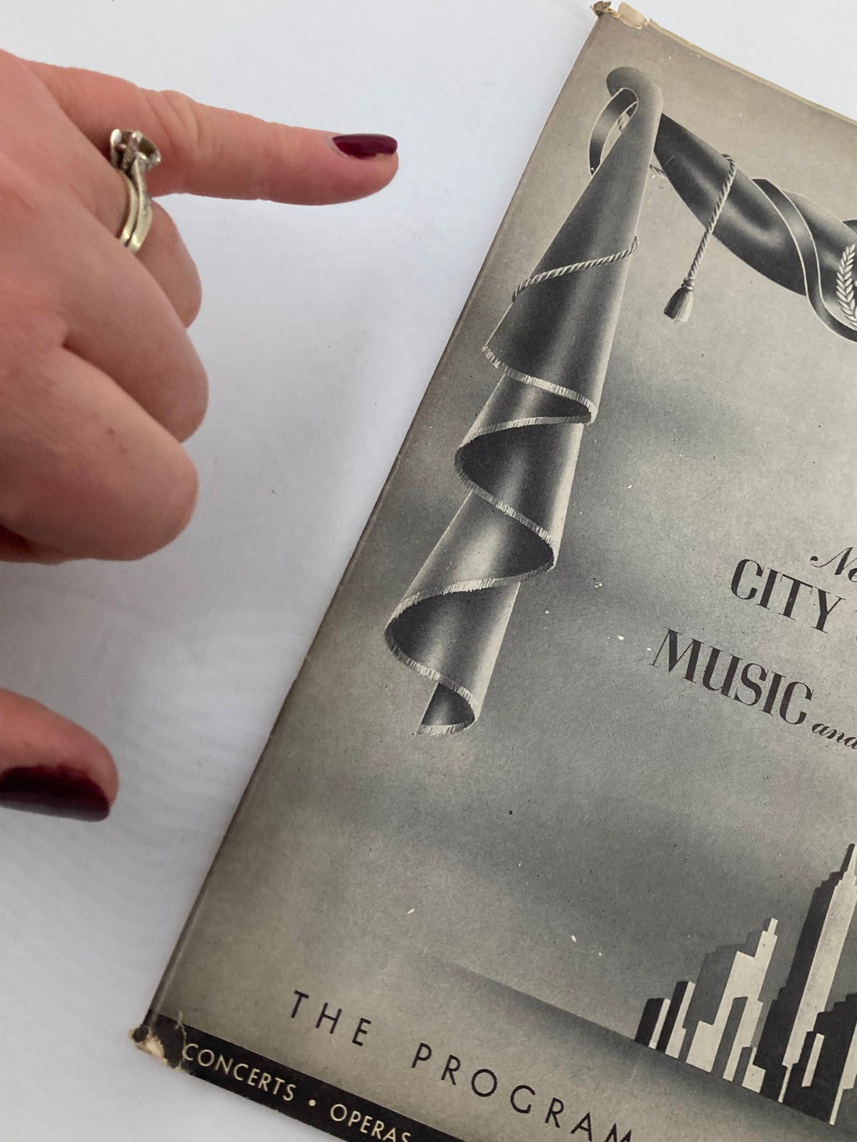 Close-up view of the cover of 1948 Program Magazine New York City Center, showing a hand pointing at the artistic curtain design.
