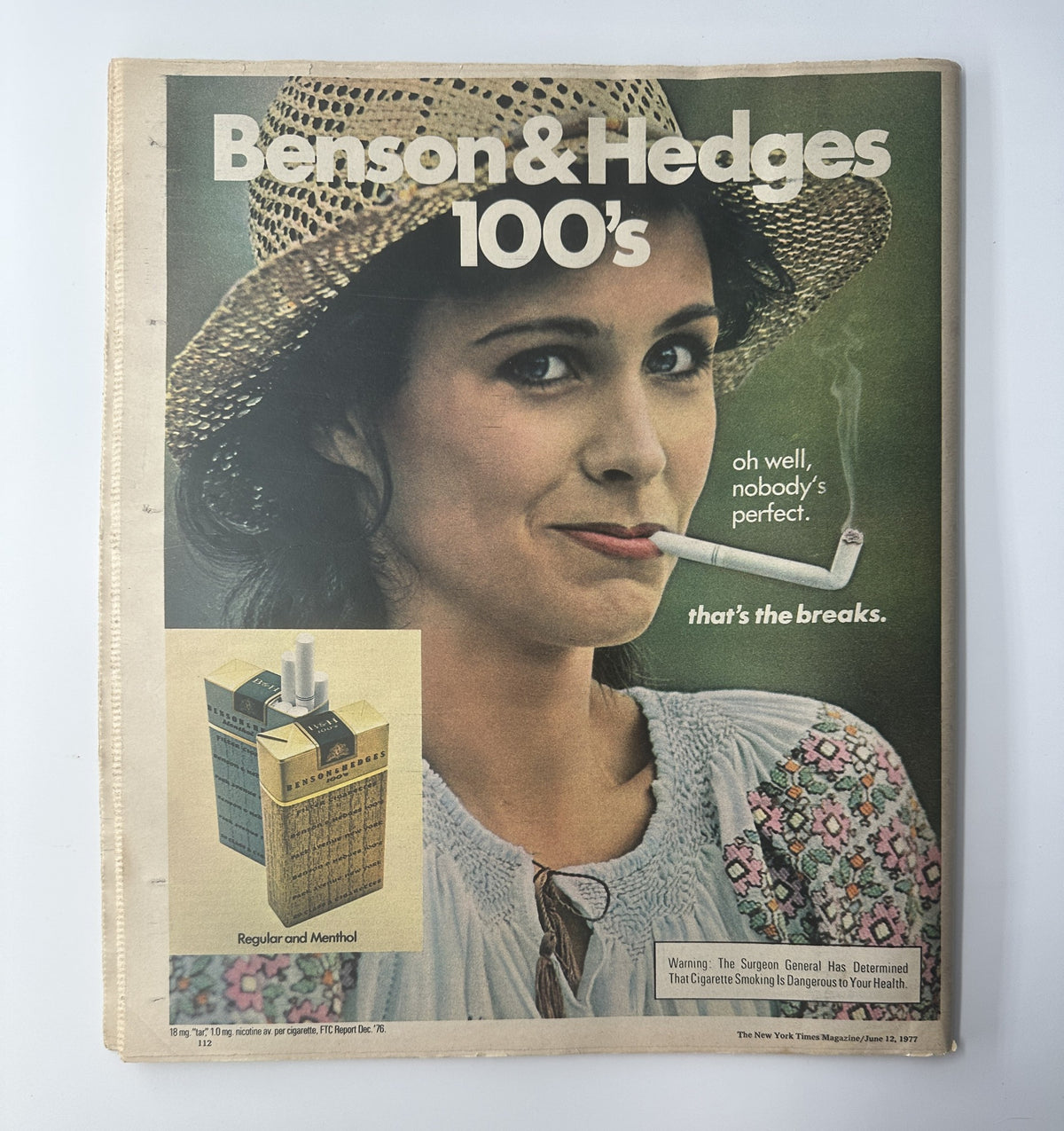 Vintage advertisement for Benson & Hedges 100s from The New York Times Magazine June 12, 1977, showcasing a young woman with a cigarette, highlighting the tagline 'oh well, nobody's perfect'.