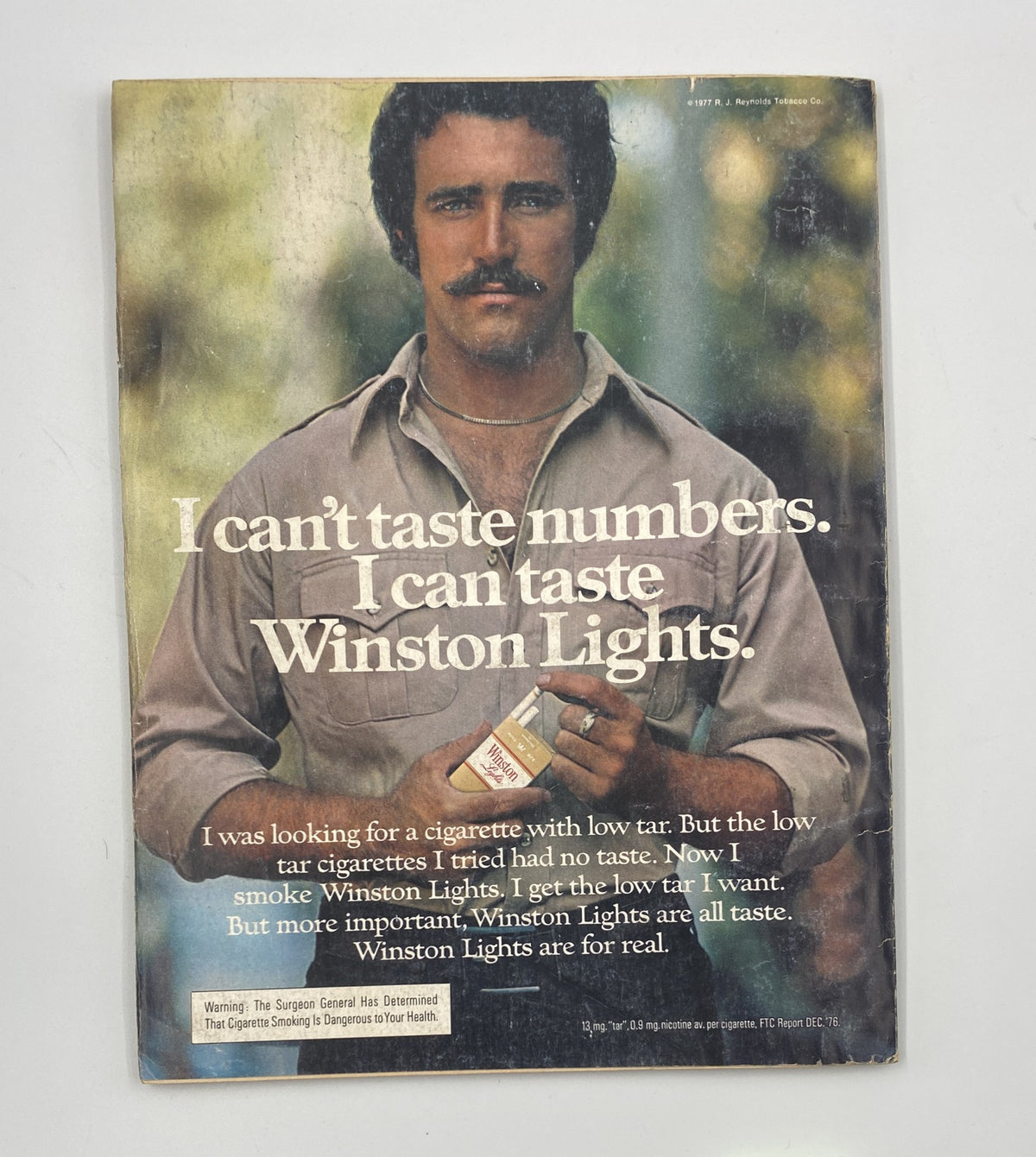 Back cover of Esquire Magazine July 1977 featuring an advertisement for Winston Lights cigarettes with the tagline 'I can't taste numbers. I can taste Winston Lights.' highlighting the brand's low tar offerings.