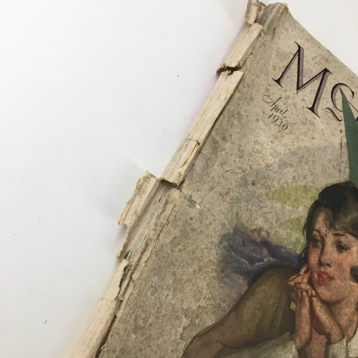 Side view of the spine of the VTG McCall's Magazine April 1930, featuring visible wear and tear, emphasizing its vintage charm and the title 'The Fifth Horseman' by Robert Chambers.