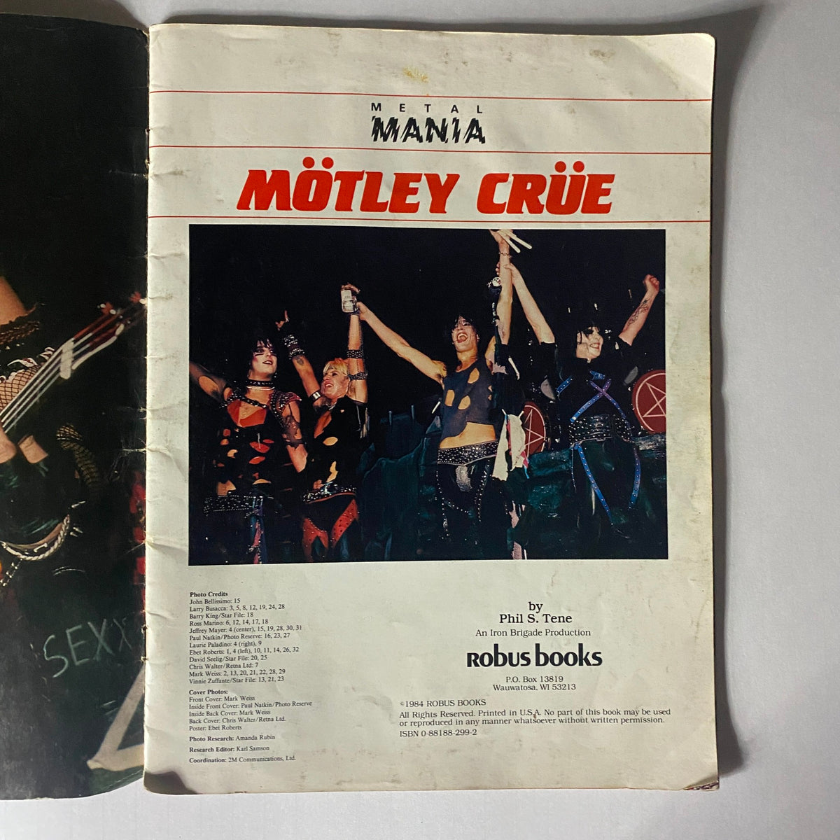 Interior page of the 1984 Mötley Crüe Metal Mania magazine displaying the band performing live, capturing the electrifying atmosphere of a heavy metal concert with fans cheering.