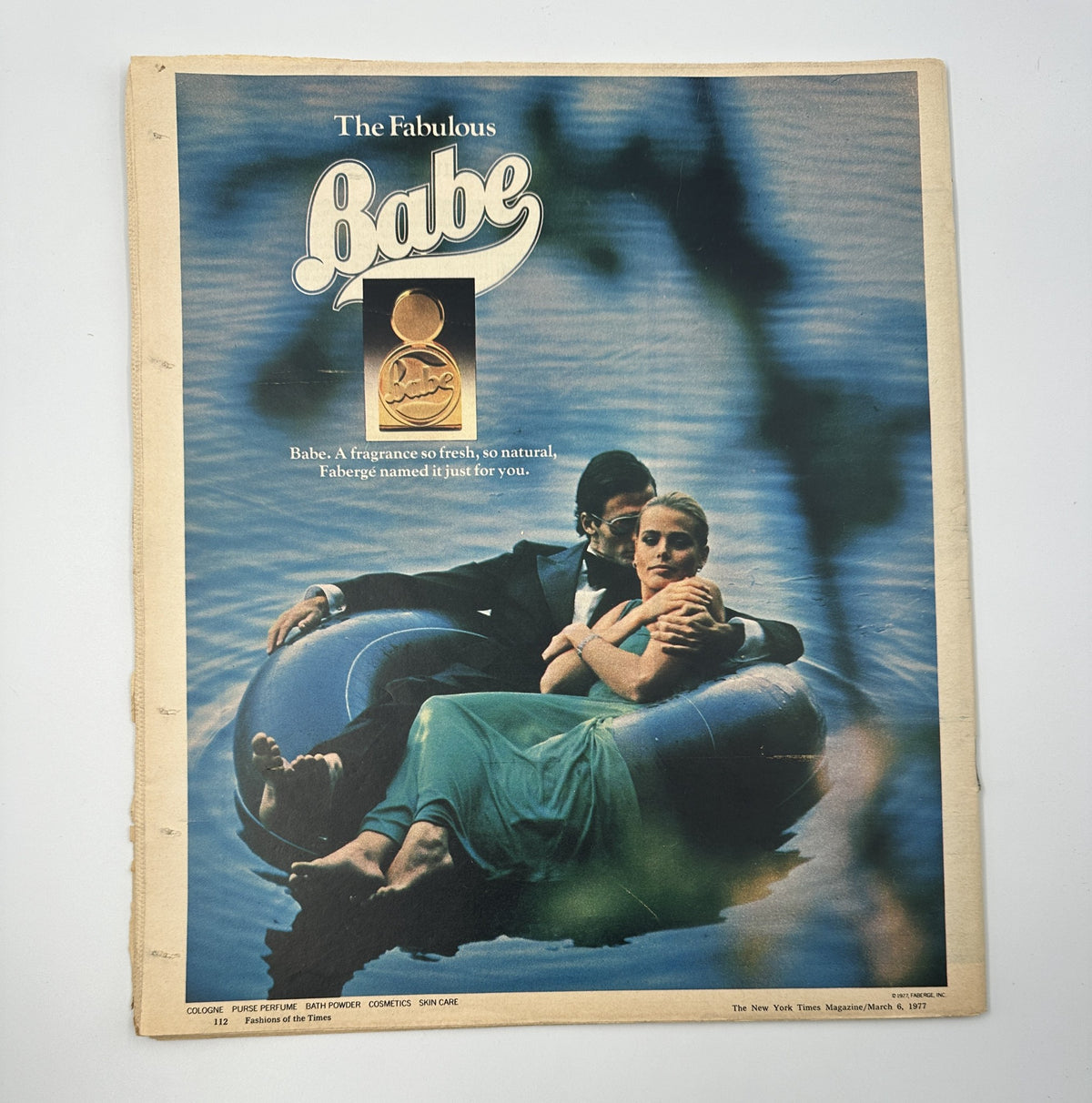 Cover of The New York Times Magazine March 6, 1977 featuring 'Babe', an advertisement showcasing a couple relaxing on an inflatable raft by the water, promoting the fragrance Babe.