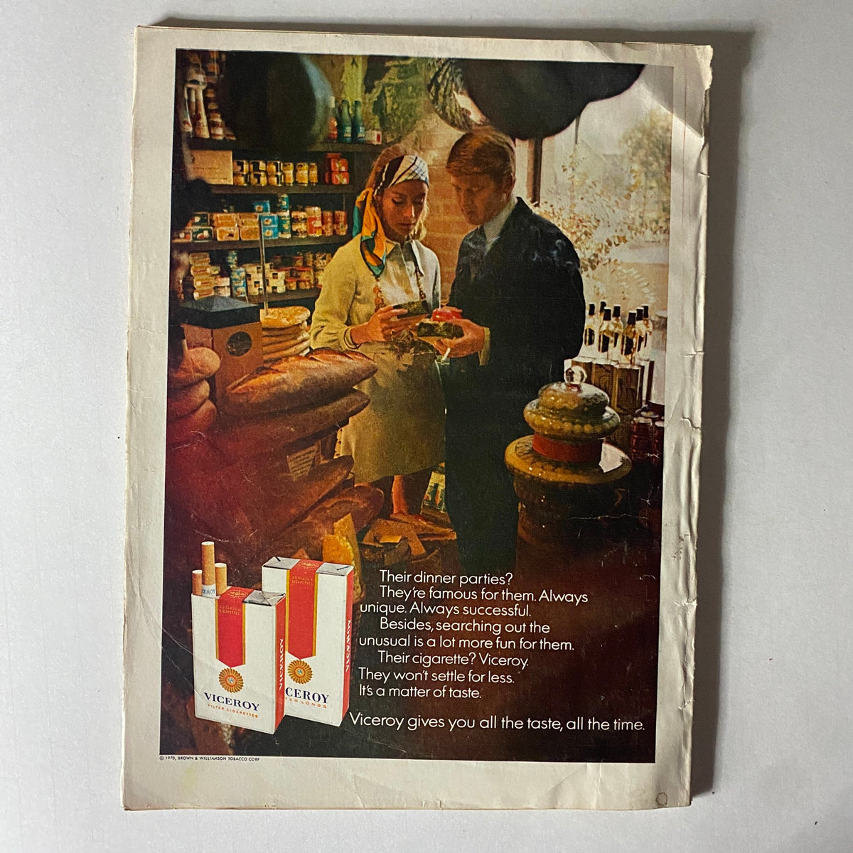 Advertisement from a vintage magazine featuring a couple discussing products in a quaint store, promoting Viceroy cigarettes with vintage aesthetic appeal.
