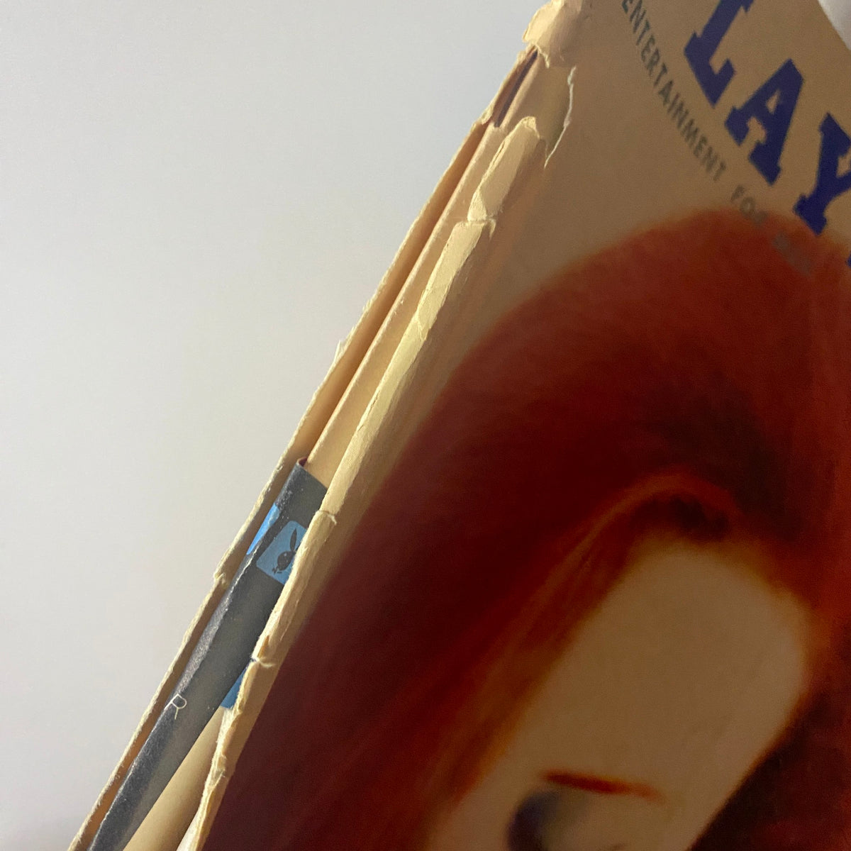 Side view of Playboy Magazine March 1960 with worn edges and binding, highlighting its vintage characteristics.