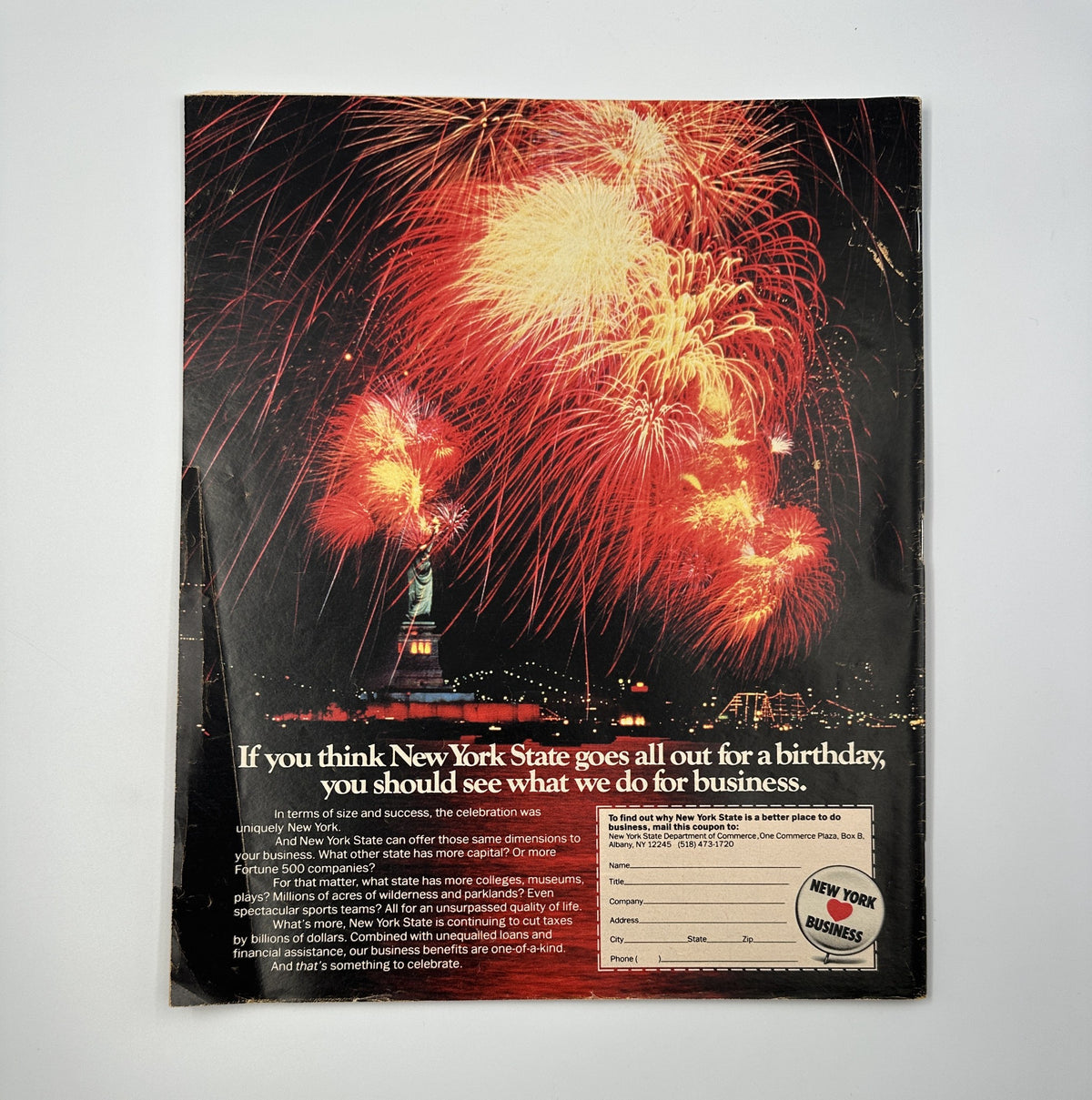 Back cover of The New York Times Magazine, dated May 3, 1987, featuring a vibrant fireworks display above the Statue of Liberty with the tagline promoting New York State's business opportunities.