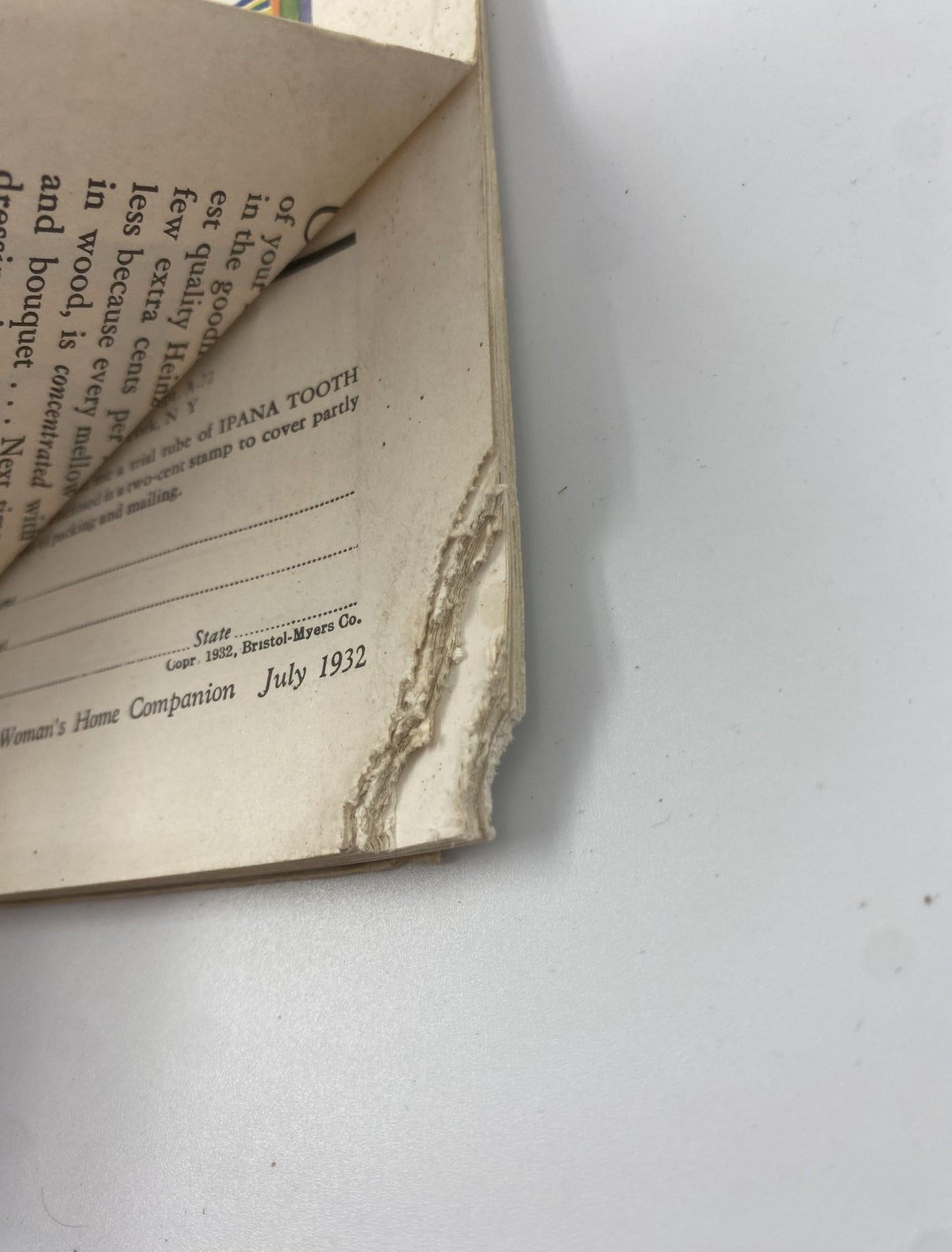 Detail of Woman’s Home Companion Magazine July 1932 showing a tear in the page, highlighting the magazine's vintage wear.