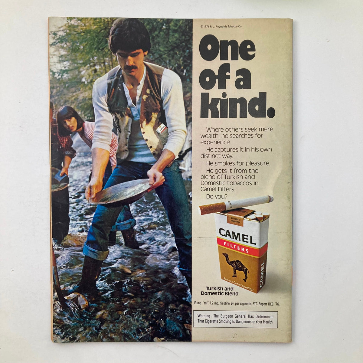 Back cover of the Crawdaddy Magazine August 1977 featuring a Camel cigarette advertisement with an outdoor scene. The ad highlights the distinctive experience associated with Camel Filters.
