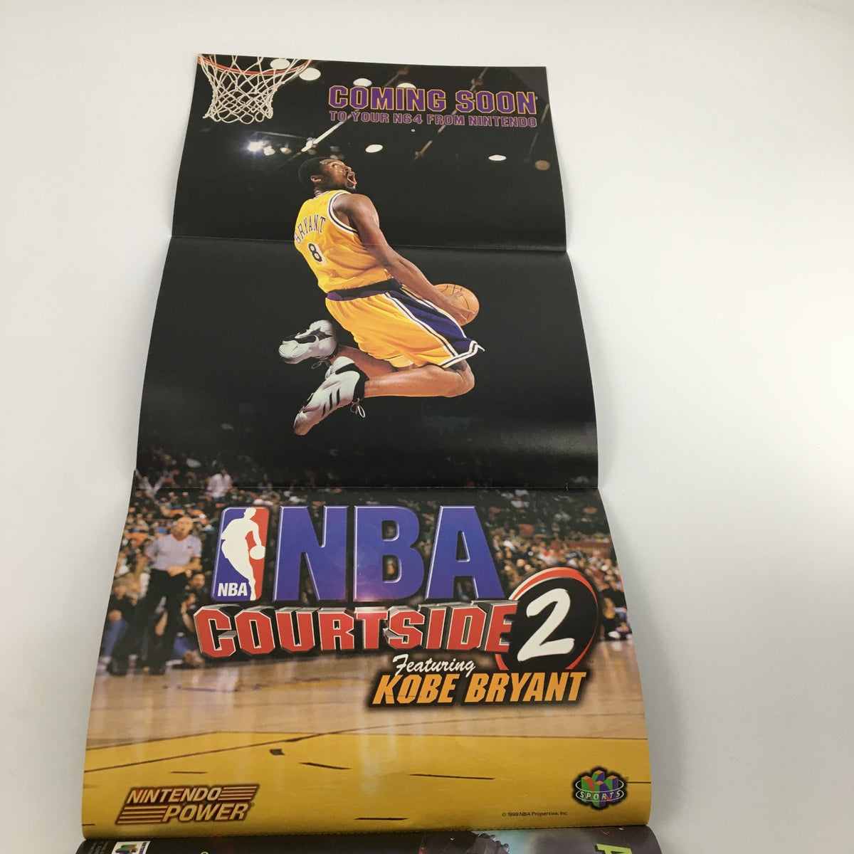 Fold-out poster from Nintendo Power Magazine November 1999 #126, featuring Kobe Bryant in action with the text 'Coming Soon to Your N64 from Nintendo' for NBA Courtside 2, a treasured collectible for sports fans.