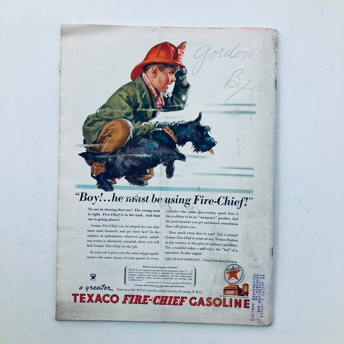 Vintage advertisement featuring a young boy in a firefighter hat and a Scottish Terrier dog, promoting Texaco Fire-Chief Gasoline. This illustration captures the nostalgic charm of early 20th-century advertising and relates to the VTG Time Magazine February 12 1934, Vol 23 No. 7 Air Commissar Kliment Voroshilov.