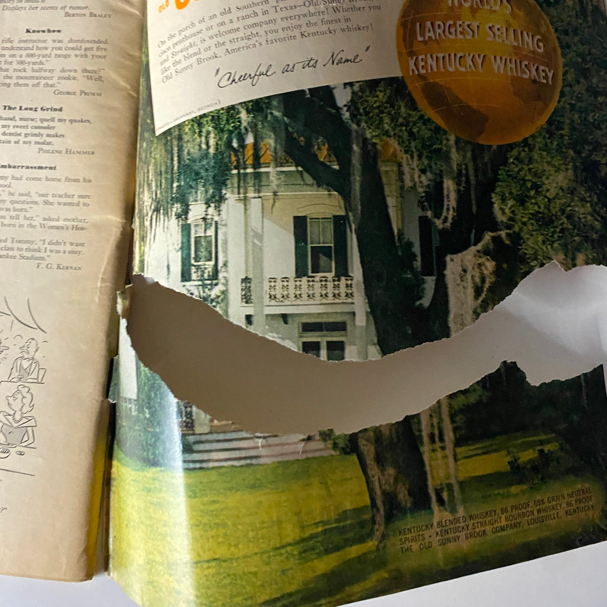The American Legion Magazine April 1954, featuring an advertisement for Old Sunny Brook whiskey with a damaged page showing a Southern mansion and text promoting Kentucky whiskey as the world's largest selling brand.