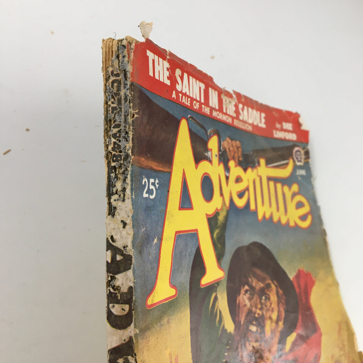 Side view of VTG Adventure Magazine June 1948 showcasing the spine with wear, highlighting its vintage character and the title 'Jackal Song'.