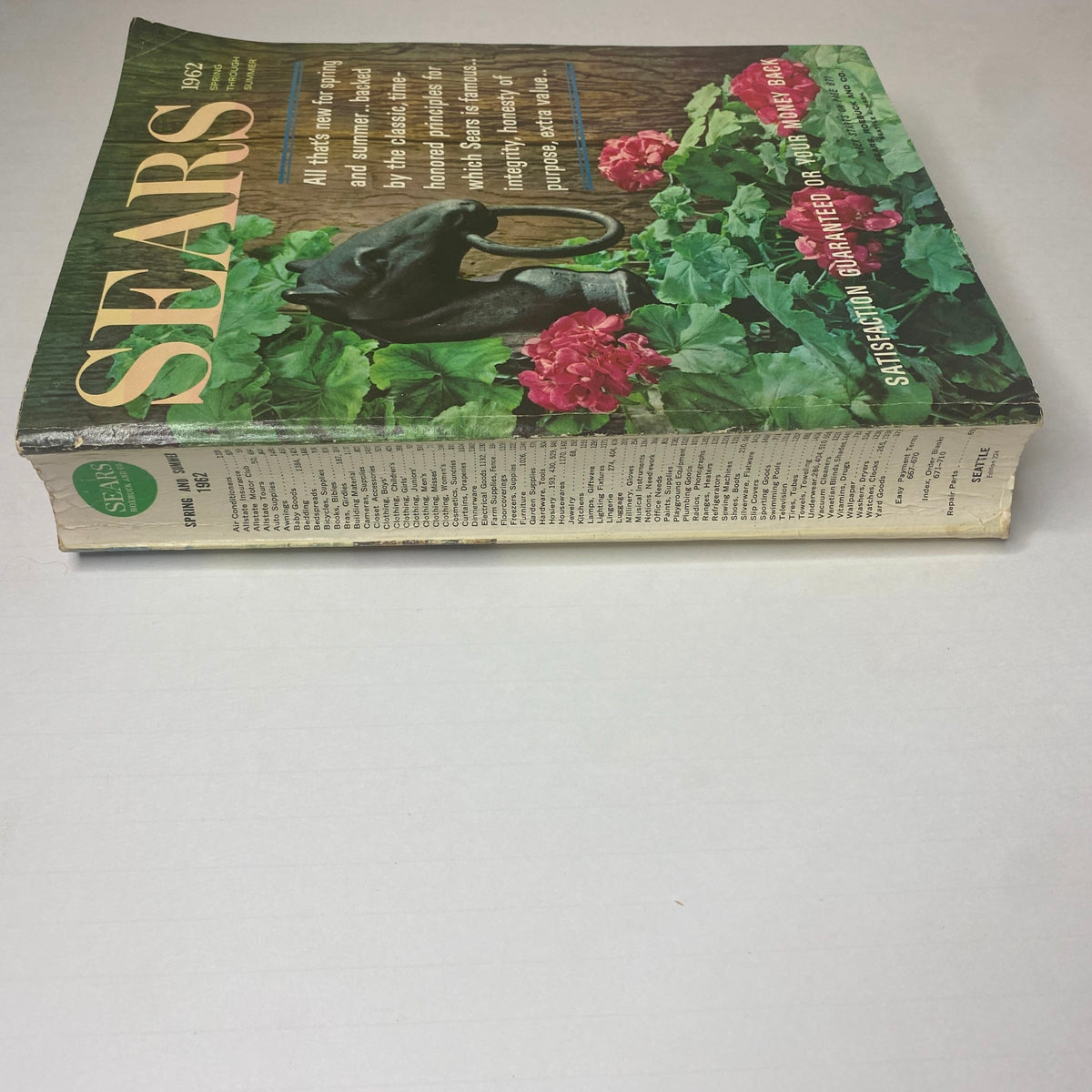 Side view of the 1962 Sears Family Patterns Spring - Summer Catalog displaying its spine and cover design with floral accents, emphasizing its collectible vintage nature.