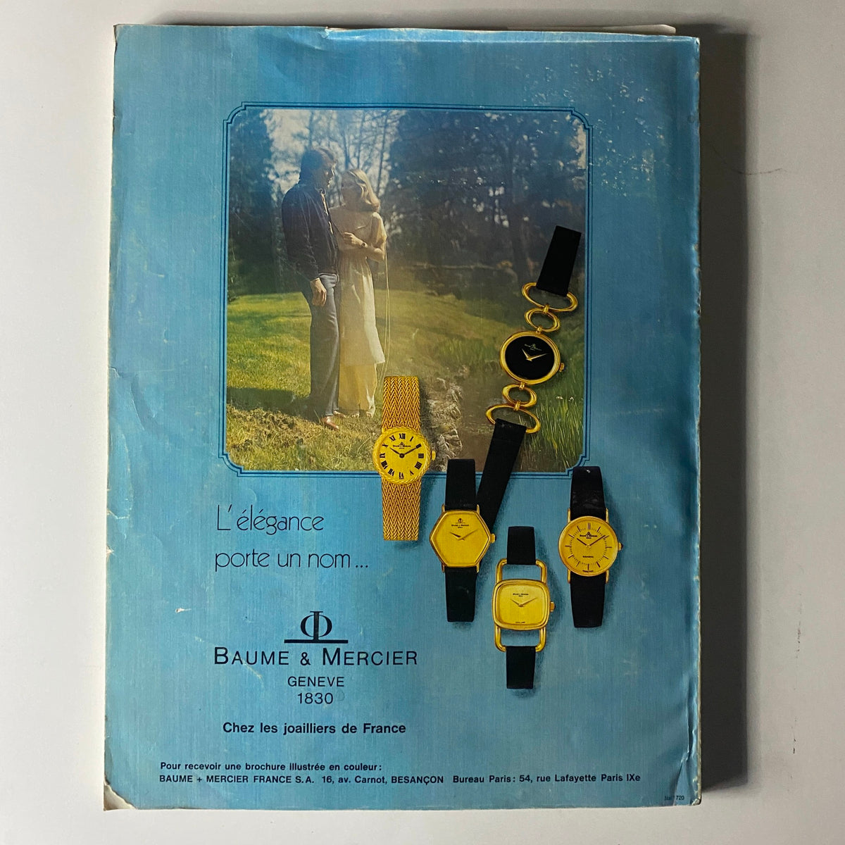 Vogue Paris Magazine April 1978 Dayle Haddon Cover No Label featuring a vintage advertisement for Baume & Mercier watches, showcasing elegant timepieces against a soft-focus background of a couple in a serene outdoor setting.
