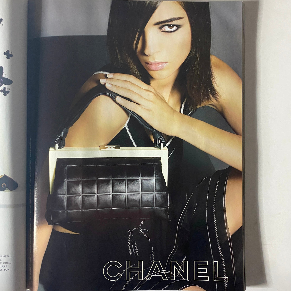 Fashion advertisement page from Vogue Paris Magazine February 2002, featuring a model showcasing a Chanel handbag.
