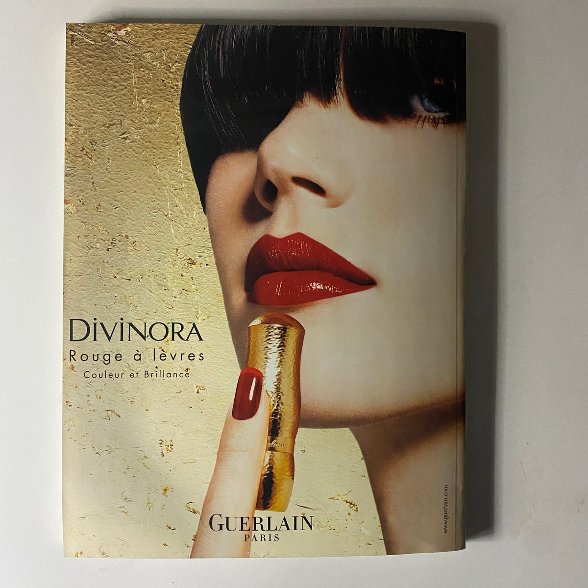 Guerlain advertisement from Vogue Paris Magazine February 2002, displaying a lipstick product with a glamorous model.