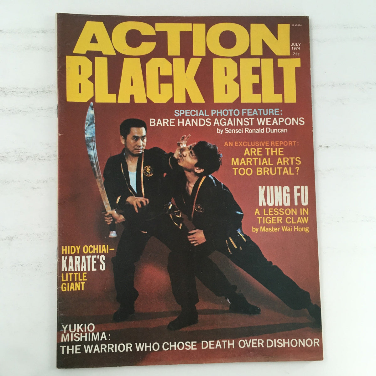 Cover of Action Black Belt Magazine July 1974 Vol 1 #1 featuring martial artists Wai Hong and Hidy Ochiai, showcasing a special photo feature on bare hands against weapons.