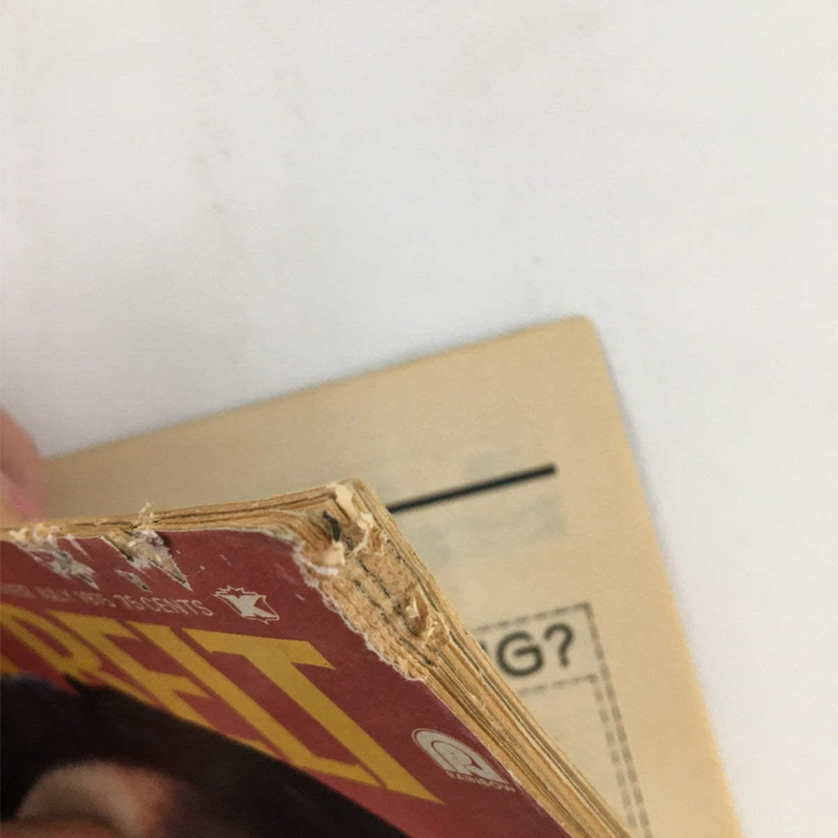 Detail of the spine of Black Belt Magazine July 1975, illustrating the magazine's age with frayed edges.