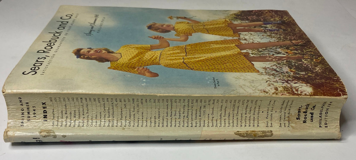 Side view of the 1942 Sears, Roebuck and Co. Spring and Summer Catalog showcasing the vintage spine and cover design with women and children in period clothing.