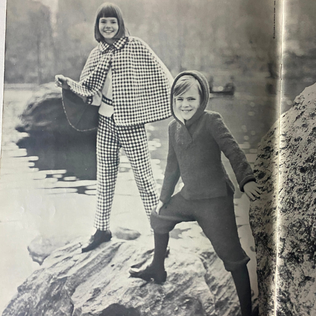 A black and white photograph featuring a girl in a checked outfit and a boy in a sweater from the 1966 Knits for Kids and for the Young by Columbia Minerva.