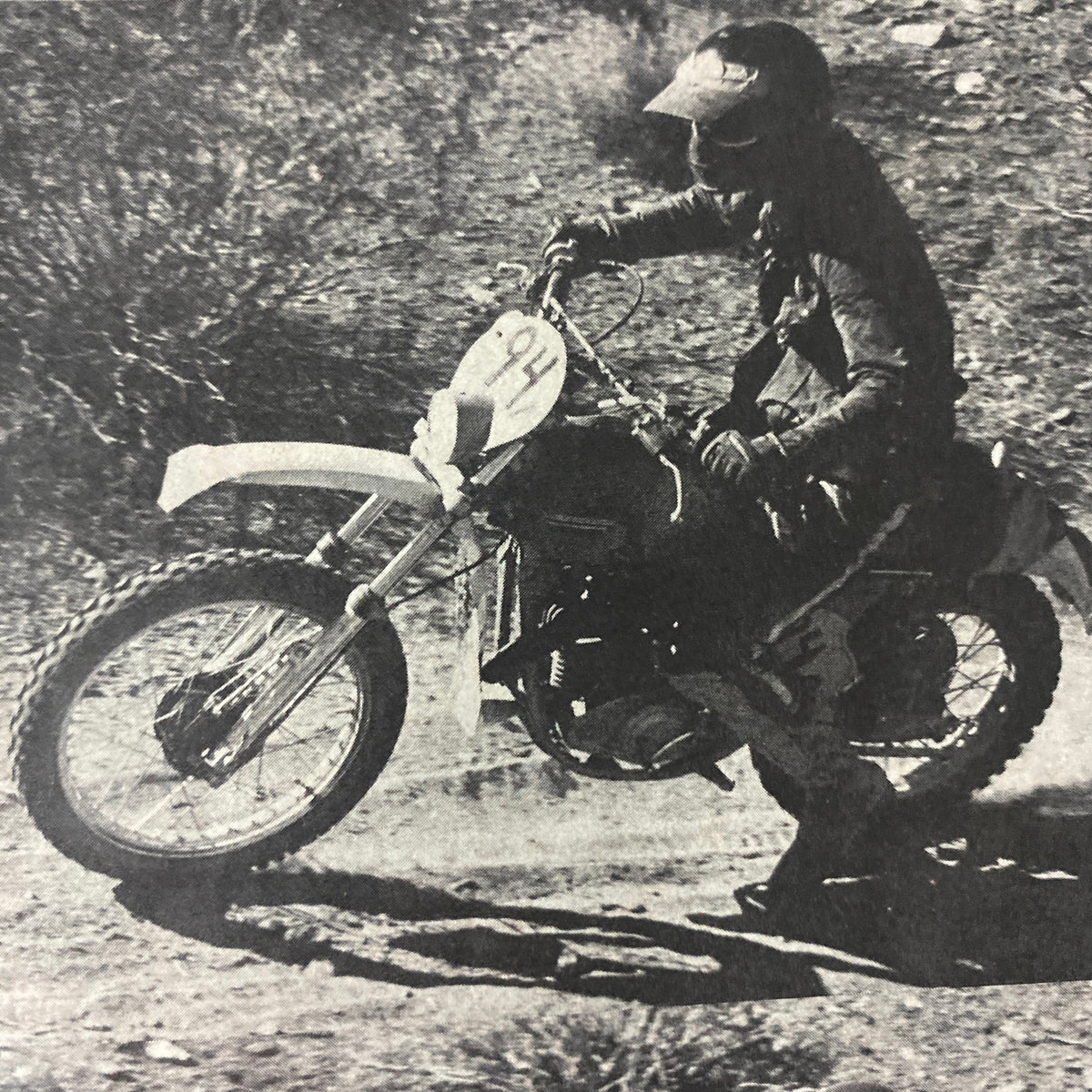 Interior page of Cycle World Magazine August 1976 showing a vintage image of a rider on a dirt bike, number 94, racing through rugged terrain during an event.