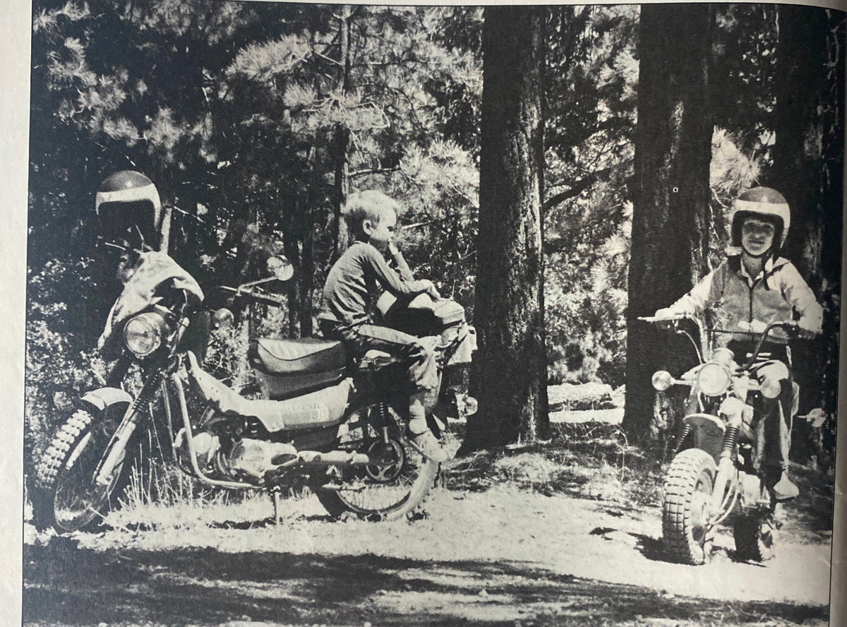 Black and white photograph in Cycle Guide Magazine November 1979 showing children riding motorcycles in a forest, reflecting the adventurous spirit of 1970s motorcycle culture.
