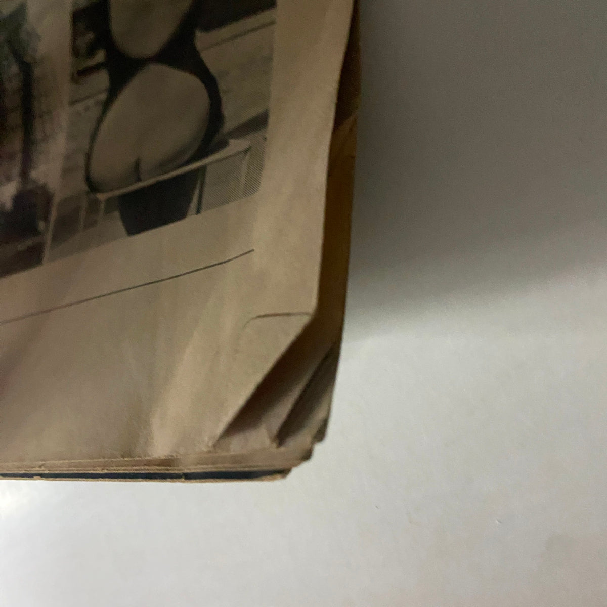 Close-up of the edge of Caper Magazine November 1965, Volume 11, No. 6 showing a worn corner, indicative of vintage magazine condition.