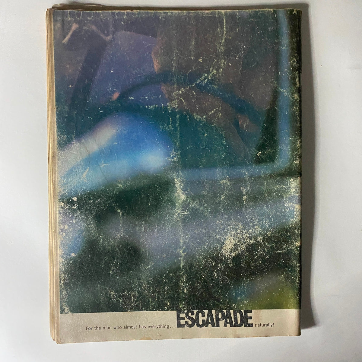 The damaged cover of Caper Magazine November 1965, Vol 11 No. 6, featuring the text 'Escapade' and showcasing the wear characteristic of vintage magazines, reflecting the passage of time.