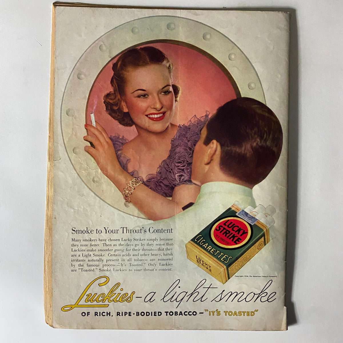 A vintage advertisement from Life Magazine October 1936 for Lucky Strike cigarettes, featuring a smiling woman and a man, conveying the marketing style of the era.