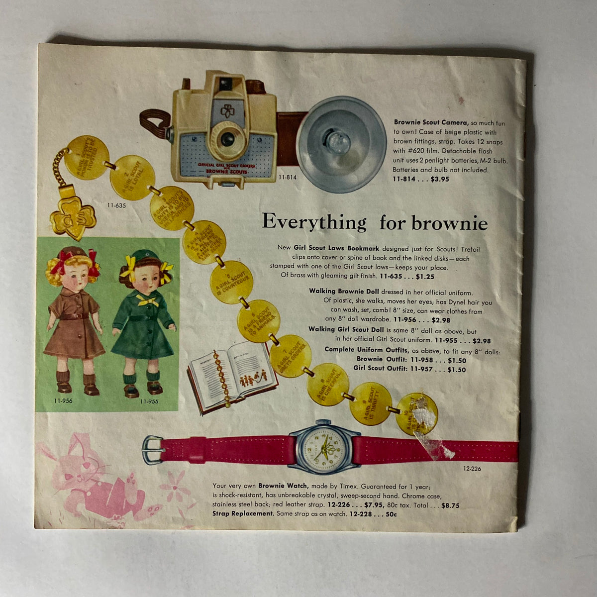 Collectible items in the "Brownie Scout Equipment Fall 1958 Spring 1959 Catalog", displaying a range of accessories including a Brownie Scout camera, dolls, and watch, with details on pricing and descriptions for historical scouting memorabilia.