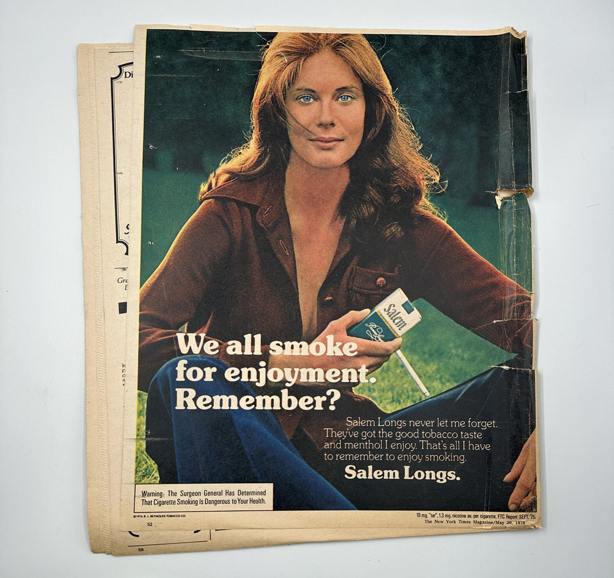 Advertisement from The New York Times Magazine May 30, 1976, promoting Salem Longs cigarettes with the tagline 'We all smoke for enjoyment. Remember?' featuring a woman holding a cigarette.