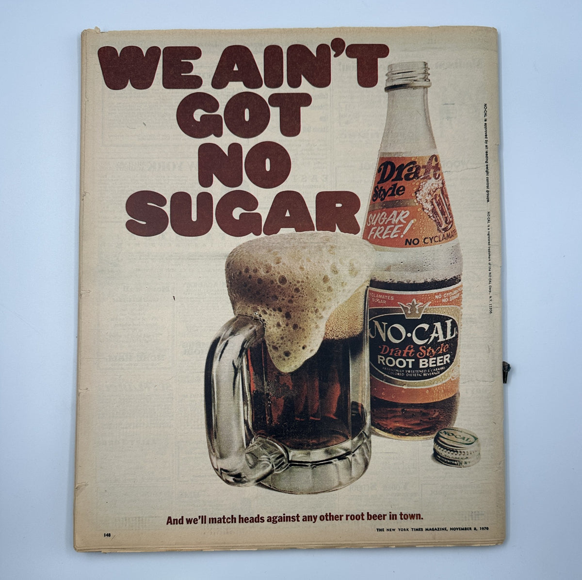 Ad from The New York Times Magazine November 8, 1970, promoting No-Cal Draft Style Root Beer, showcasing a frothy mug of root beer next to a bottle, with headline 'WE AIN'T GOT NO SUGAR'.