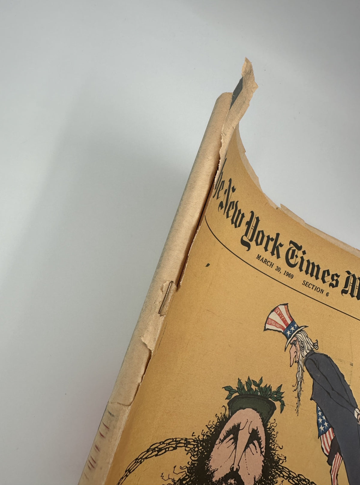 Side view of The New York Times Magazine from March 30, 1969, depicting damage to the spine with visible wear, confirming its vintage condition.
