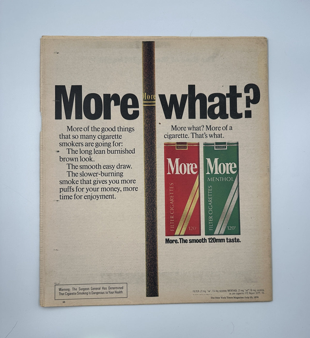 Back cover of The New York Times Magazine July 25, 1976, advertising More Cigarettes, highlighting the phrase 'More-what?' with a focus on two cigarette packs.
