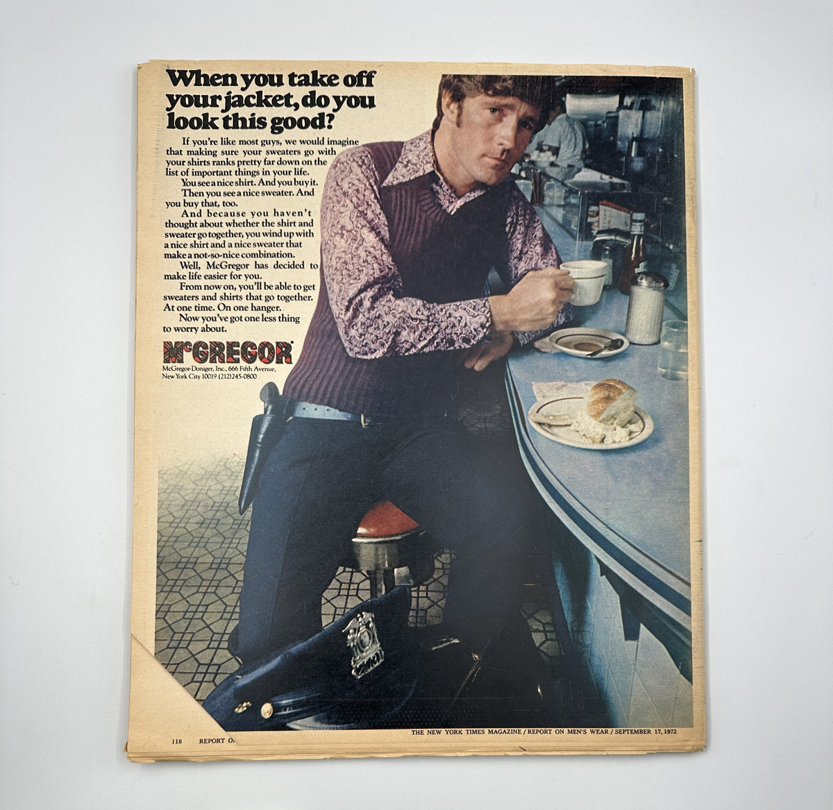 Advertising image from The New York Times Magazine September 17, 1972, featuring a man in a stylish knitted vest and slacks at a diner, promoting McGregor menswear and reflecting 1970s style.