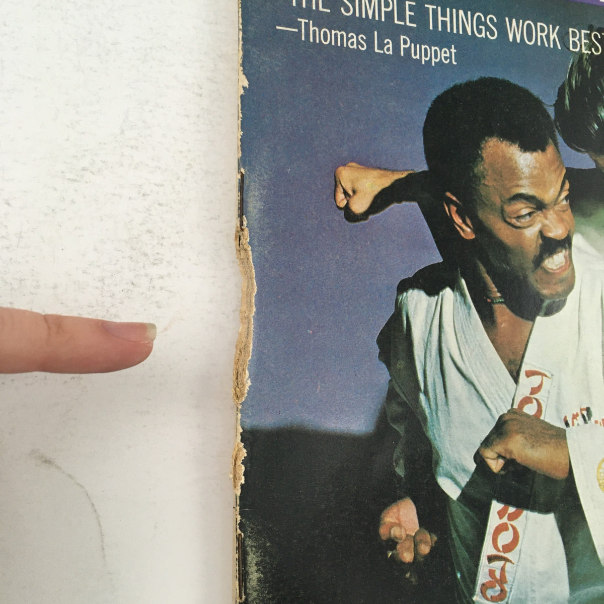 Close-up of the worn edge of the Karate Illustrated Magazine January 1971, Vol 2 #1, showcasing its vintage condition and wear, reflecting the magazine's age and history.