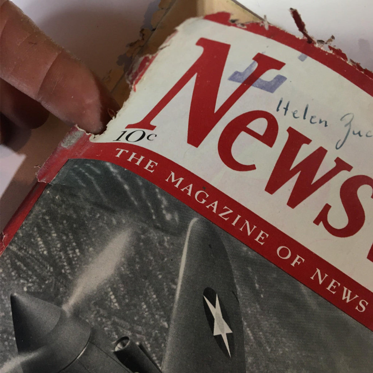 Detailed view of the Newsweek Magazine October 7, 1940 featuring the title and damage on the cover emphasizing its vintage condition.