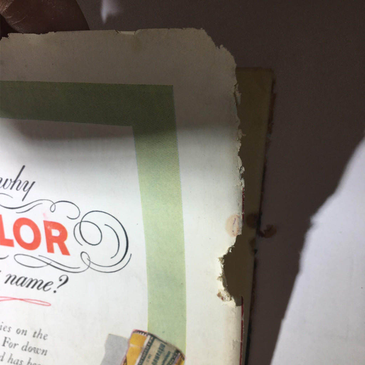 Another angle of the torn advertisement page for Old Taylor Bourbon, capturing historical details and the condition of vintage marketing materials.