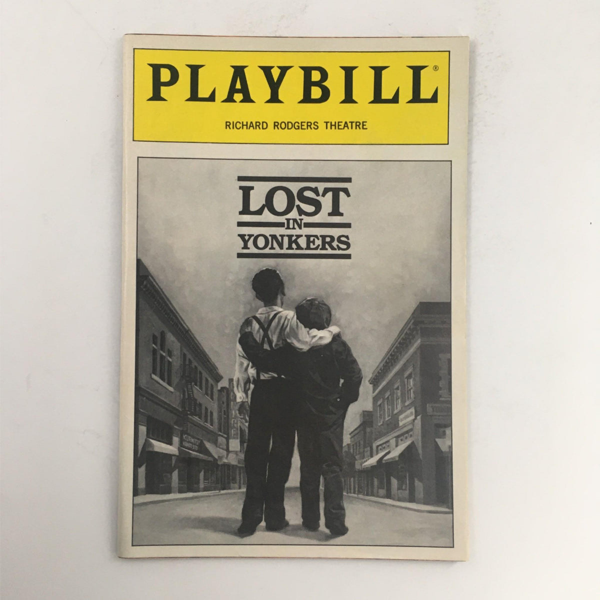 1991 Playbill for Lost in Yonkers by Neil Simon, featuring a black and white cover image of two boys standing back to back on a street.