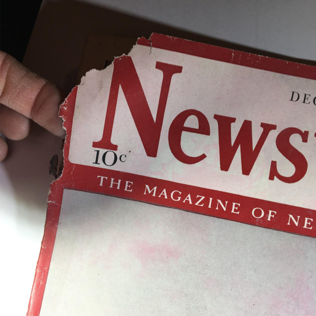 Close-up view of the damaged corner of Newsweek Magazine dated December 22, 1941, showcasing the title and dated content with visible wear.