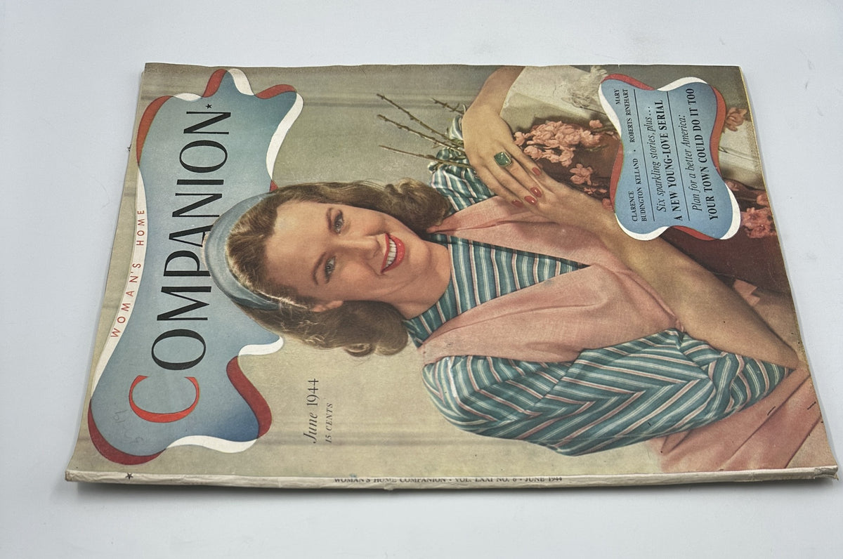 Close-up view of the Woman’s Home Companion Magazine June 1944 cover with an image of a woman in a pink dress and striped top, smiling and posing with flowers. The title and month are prominently featured.