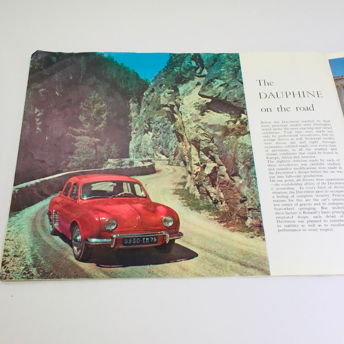 Vintage 1956 Renault Dauphine 4-Speed MT car brochure featuring a red Renault Dauphine on a winding road, showcasing mid-century automotive design.
